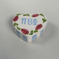 a small heart shaped trinket box decorated with flowers and the word tbg