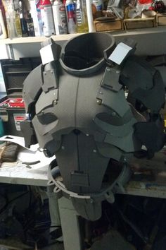 a large metal object sitting on top of a workbench in a room filled with lots of clutter