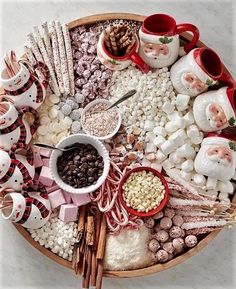 a platter filled with candy, marshmallows and santa clause figurines