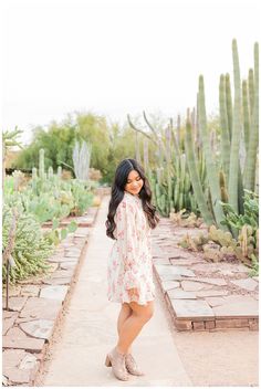 a woman standing in front of cacti