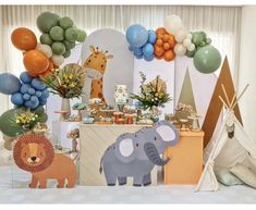 an elephant, giraffe and lion themed birthday party setup with balloons in the background