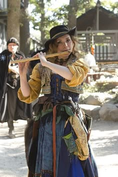 a woman dressed in costume holding a stick