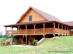 a large wooden house sitting on top of a lush green hillside