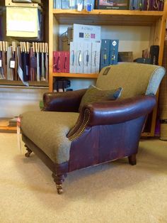 a chair sitting in front of a bookshelf filled with lots of book cases