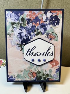 a thank card with flowers and the word thanks on it, sitting on a table