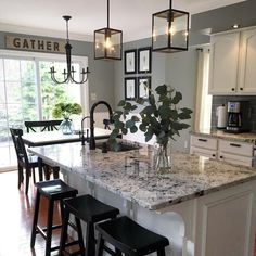 a kitchen island with marble counter tops and stools