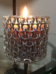 a lit candle sitting on top of a glass table