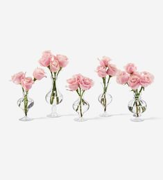 three clear vases with pink flowers in them