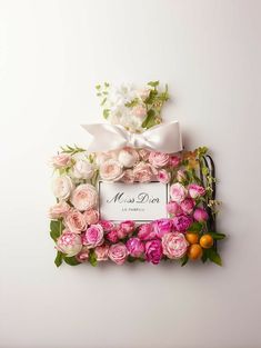 pink and white flowers are arranged around a sign