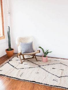 a chair sitting on top of a wooden floor next to a potted plant