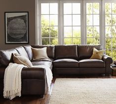 a living room scene with focus on the couch and large window in the back ground