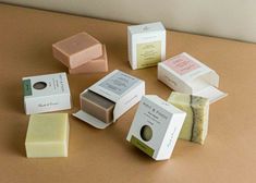 several different types of soaps sitting on top of a brown table next to each other