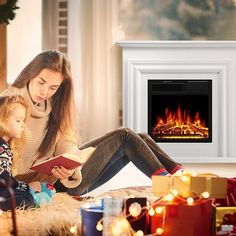 a woman and child sitting on the floor in front of a fireplace reading a book