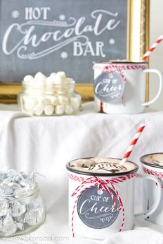 two mugs filled with hot chocolate on top of a table