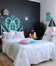 a bedroom decorated in pastel colors with teepees and stars on the walls