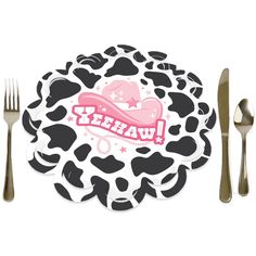 a black and white cow print plate with utensils