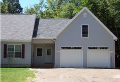 a white house with two garages on the front and one attached to the side