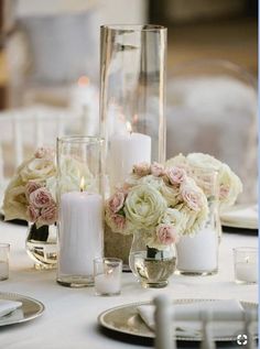 the centerpieces are filled with flowers, candles and glass vases on the table