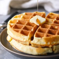 a plate with waffles and syrup being drizzled on top