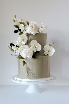 a three tiered cake with white flowers on top