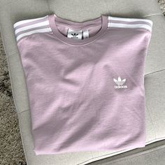 Adidas Originals T-Shirt In Like-New Condition, Never Worn Logo On Heart And On Sleeve With Stripes On Shoulders Light Pinkish-Purple Pastel Colorway Purple Crew Neck Top With Letter Print, Purple Letter Print Crew Neck Top, Purple Relaxed Fit Sporty Tops, Spring Lavender Letter Print Top, Sporty Purple Tops With Graphic Print, Lavender Relaxed Fit Crew Neck Top, Sporty Purple Top With Letter Print, Casual Lavender T-shirt With Letter Print, Basic Purple Tops With Graphic Print