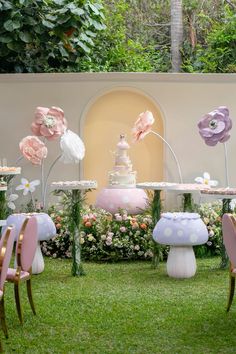 a table with cake and flowers on it in the grass