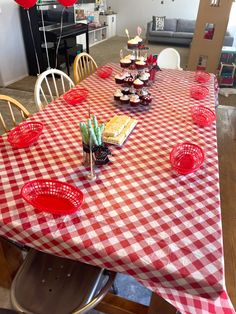 a red and white checkered table cloth with cupcakes on it in the middle