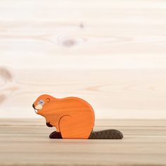 a wooden toy beaver sitting on the ground