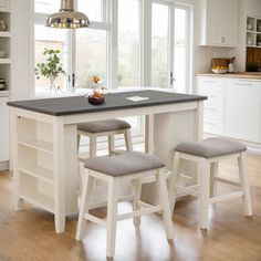 a kitchen island with two stools in front of it and an open window to the outside