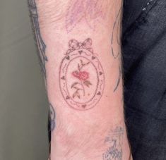 a person with a tattoo on their arm holding onto the wrist and wearing a watch