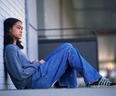 a woman sitting on the side of a building