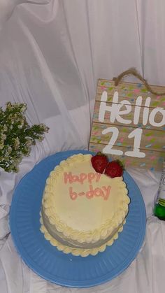 a birthday cake sitting on top of a blue plate next to a sign that says hello 21st