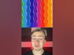 a man with blonde hair standing in front of a multicolored rainbow wallpaper