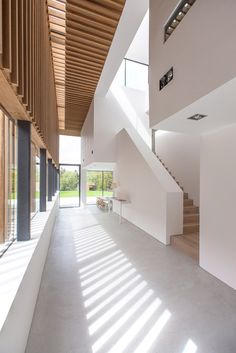 the interior of a modern house with white walls and wood ceilinging, along with large windows