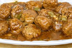 meatballs and peppers in gravy on a white plate, ready to be eaten