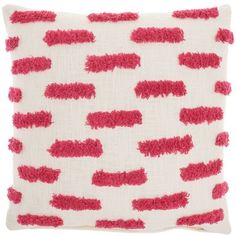 a red and white pillow with pink fringes on it's side, in front of a white background