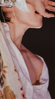 a woman with her hand on her face and wearing a white towel around her neck