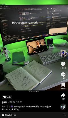 a computer monitor sitting on top of a desk next to a keyboard and mouse with an open book