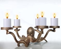 an octopus candelabra with three candles on it's arms and two smaller ones in the middle