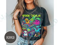 Celebrate Halloween in Y2K style with this vibrant and fun "Spook-tacular" T-shirt! This Comfort Colors Tee features an eye-catching design with neon-colored ghosts rocking retro gear. The ghosts are decked out with cassette tapes, boomboxes, high-top sneakers, and headphones, bringing a nostalgic Y2K twist to the Halloween season. The playful graphics and bold colors make this tee perfect for any Halloween party or casual wear, combining the best of early 2000s fashion with a spooky vibe. Comfo Y2k Style Halloween T-shirt With Screen Print, Halloween Rave Tops With Graphic Print, Trendy Halloween Concert T-shirt, Rave Tops With Graphic Print For Halloween, Halloween Y2k, Neon Halloween, Playful Graphics, Clothes Wishlist, Y2k T Shirt