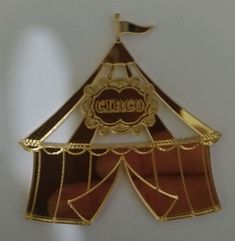 a gold colored brooch with the word ciro on it's front and side