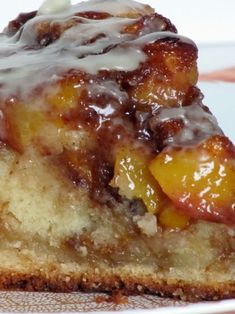 a close up of a piece of cake on a plate with icing and fruit