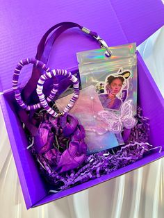 a purple box filled with lots of different items and a bag on top of it