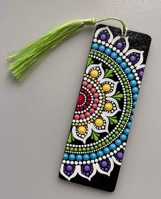 a colorful bookmark with a tassel hanging from it's side on a table