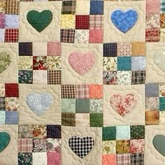 a patchwork quilt with many hearts on the front and back, all in different colors