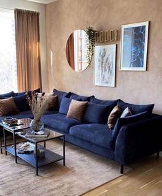 a living room with blue couches and pictures on the wall above them, along with a coffee table