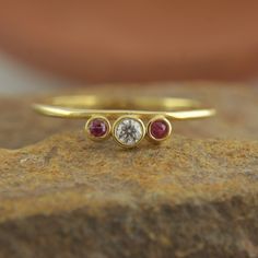 three stone ring sitting on top of a rock