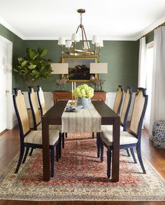 a dining room table with chairs and a rug on the floor in front of it