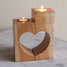 two wooden blocks with candles in the shape of a heart