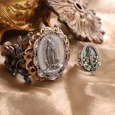 This ring is inspired by sentimental vintage French jewelry, Our Lady, Mary, mother of Jesus, stands in an oval frame with tiny flowers and leaves set with ice crystal. The frame is inscribed with the verse of the Miraculous Medal, a prayer for intercession and assistance. "O Mary conceived without sin pray for us who have recourse to thee." Choice of silver finish with pale turquoise lacquer background or burnished bronze. åÊ Adjustable, comfortable ring band fits sizes 6-9. Made in our Los Angeles studio. åÊ From our Artifacts Ring Collection featuring old world icons of beauty, mystery and a hint of magic. Enduring symbols of legend, inspiration and guidance, they connect past with present for this journey called life. Using traditional bench techniques, every ring is hand-fabricated wi Vintage Adjustable Jewelry For Mother's Day, Victorian Jewelry With Miraculous Medal For Gifts, Vintage Jewelry With Miraculous Medal For Memorial, Antique Jewelry With Miraculous Medal For Collectors, Vintage Antique Silver Oval Ring, Victorian Hallmark Jewelry For Memorial, Victorian Memorial Jewelry With Hallmark, Vintage Oval Antique Silver Rings, Vintage Hallmark Ring